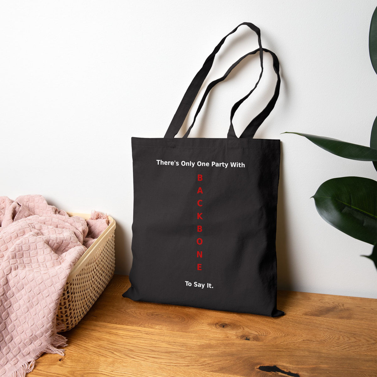 Black canvas tote bag with 'There's Only One Party With BACKBONE To Say It' in red and white text
